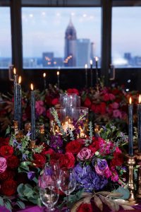 colorful reception tables purple pink red gold maroon candles flowers